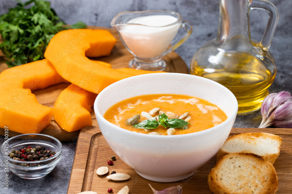 Pumpkin cream soup with seeds on a stone background, with copy space Pumpkin cream soup with seeds on a stone background, with copy space