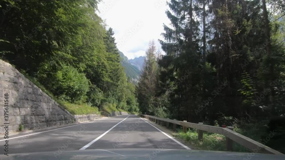 Dashboard dash cam point of view POV driving on curved countryside paved road in Slovenia. Hills and mountains surrounding alpine valley. Wide angle, forward moving Dashboard dash cam point of view POV driving on curved countryside paved road in Slovenia. Hills and mountains surrounding alpine valley. Wide angle, forward moving