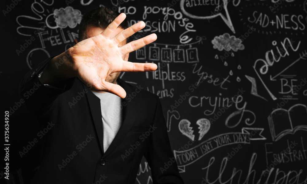 a man in depression close with his hand on the background of a drawn blackboard with problems a man in depression close with his hand on the background of a drawn blackboard with problems