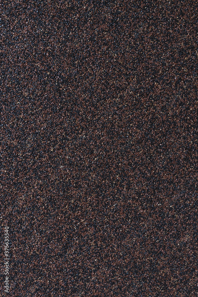 Dark wall made of varnished granite chips. Abstract construction surface. Rough industrial background. Seamless brown texture with copy space for text. Vertical photo. Dark wall made of varnished granite chips. Abstract construction surface. Rough industrial background. Seamless brown texture with copy space for text. Vertical photo.