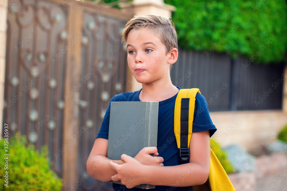 Pupil with book and backpack outdoor. Back to school Pupil with book and backpack outdoor. Back to school