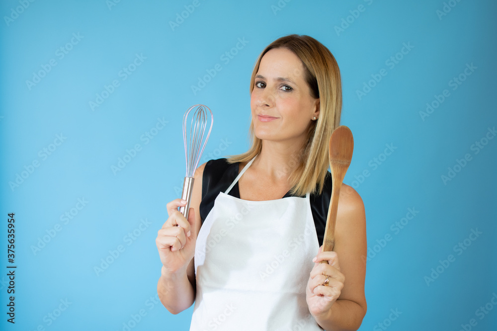 Smiling beautiful woman with apron and kitchen utensils Smiling beautiful woman with apron and kitchen utensils