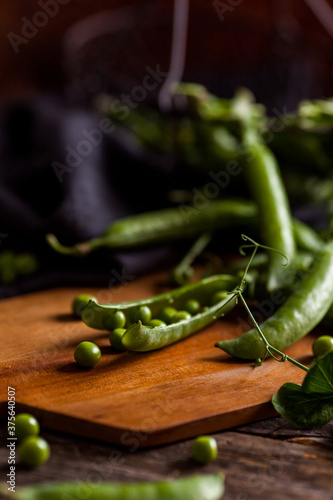 Fresh green peas pod on a wooden table close up