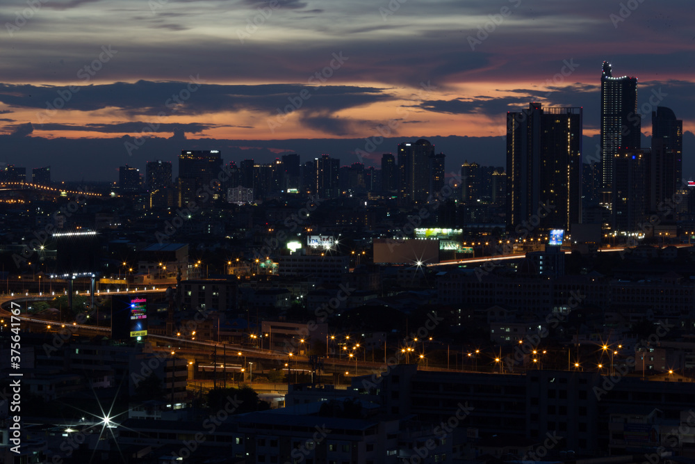 The high angle background of the city view with the secret light of the evening, blurring of night lights, showing the distribution of condominiums, dense homes in the capital community