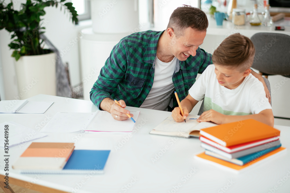 Father helping her son with homework at home. Little boy learning at home..