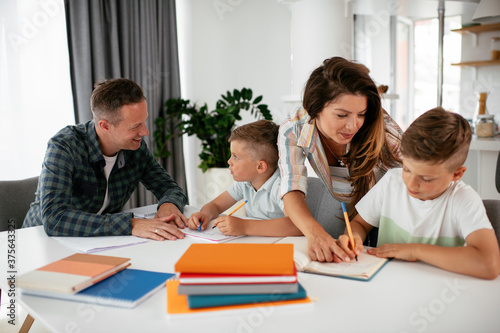 Parents helping the kids with their homework. Litlle boys learning at home..