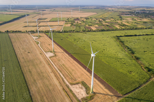 Aerial view of wind turbine generators in field producing clean ecological electricity.