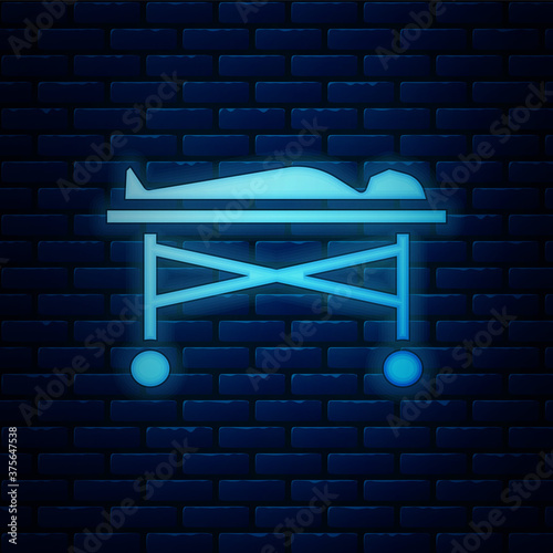 Glowing neon Dead body in the morgue icon isolated on brick wall background. Vector.