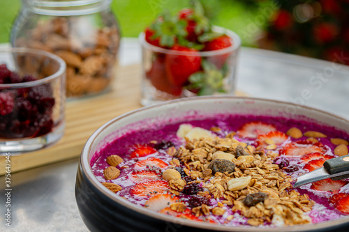 Tasty dragon fruit smoothie bowl with berries and toppings