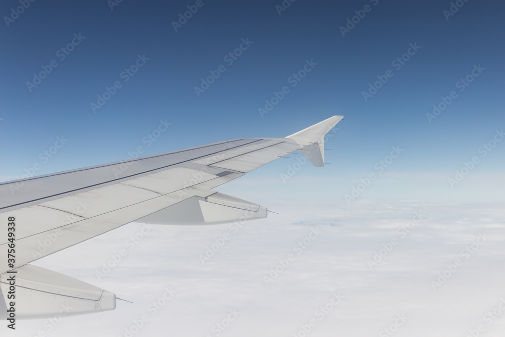 wing of an airplane that is in the air, the sky is clear with clouds in the day wing of an airplane that is in the air, the sky is clear with clouds in the day