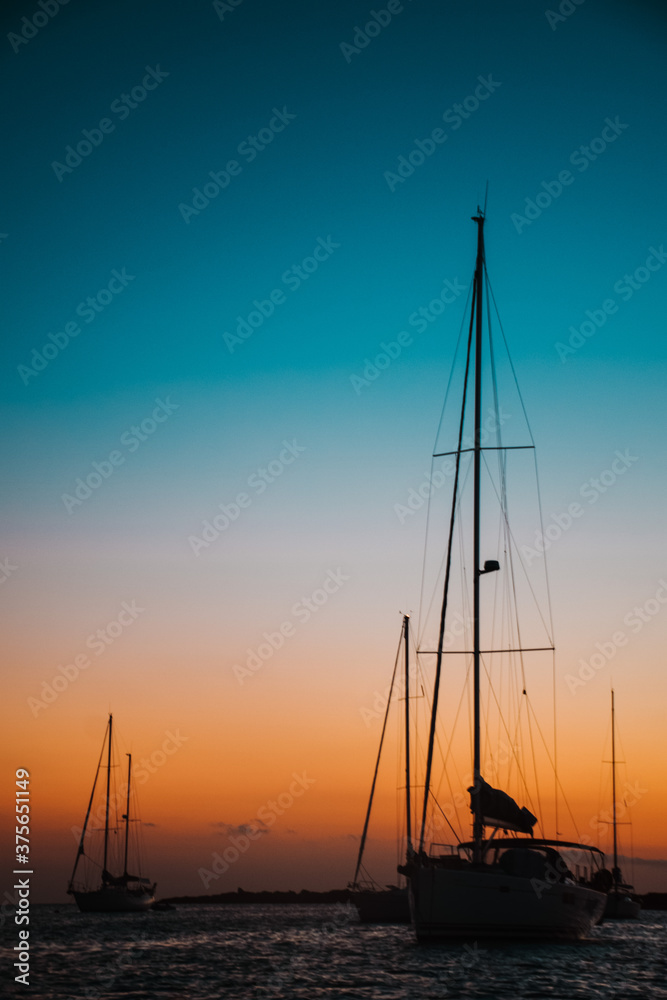 Anchored sailboats silhouette at sunset