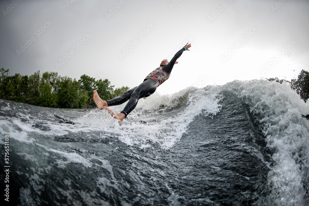 man in black swimsuit falls from surfboard into the river water. man in black swimsuit falls from surfboard into the river water.
