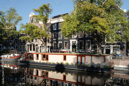 Houses and houseboat mirror in the water of the Prinsengracht right opposite the Anne Frank house in Amsterdam, early in the morning photo