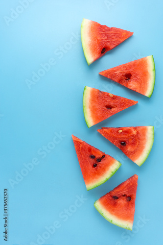Creative food health diet concept photo of sliced watermelon fruit on blue background.