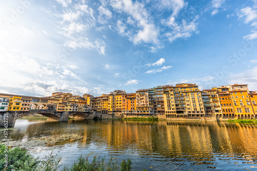 Florence Firenze, Italy orange yellow colorful buildings and Arno river water during summer morning sunrise in Tuscany wide angle view