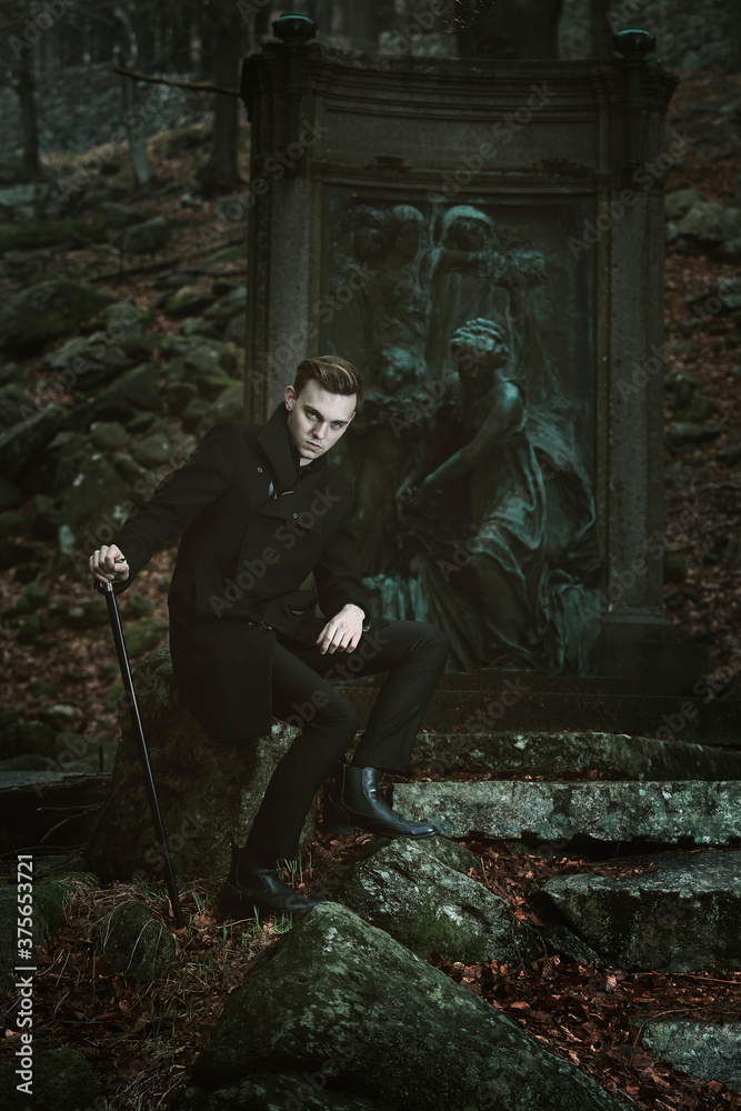 Handsome vampire posing in a cemetery