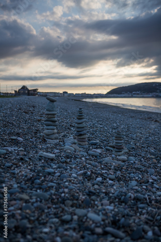 Balancing pebbles on a rocky beach in North Wales. Evening on Llandudno pebble beach