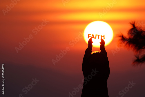Fototapeta Naklejka Na Ścianę i Meble -  Woman love silhouette in sunset with Faith text.    