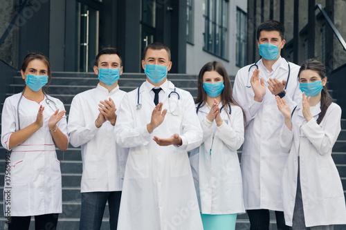 Canvas Print Medical staff from the hospital who are fighting coronavirus applaud back the people and police officers for their support