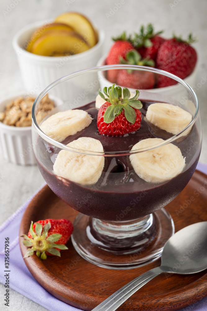 Brazilian typical acai bowl with fruits and muesli over wooden background Brazilian typical acai bowl with fruits and muesli over wooden background
