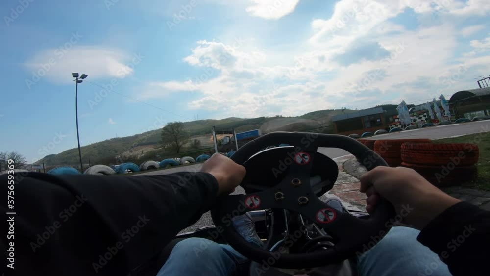 POV young man go-kart racer is driving in an outdoor go karting circuit