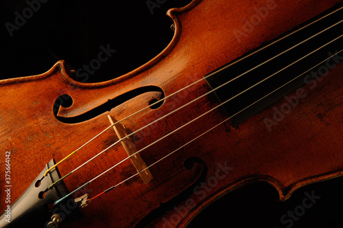 Close up a antique French volin with dramatic lighting on black background