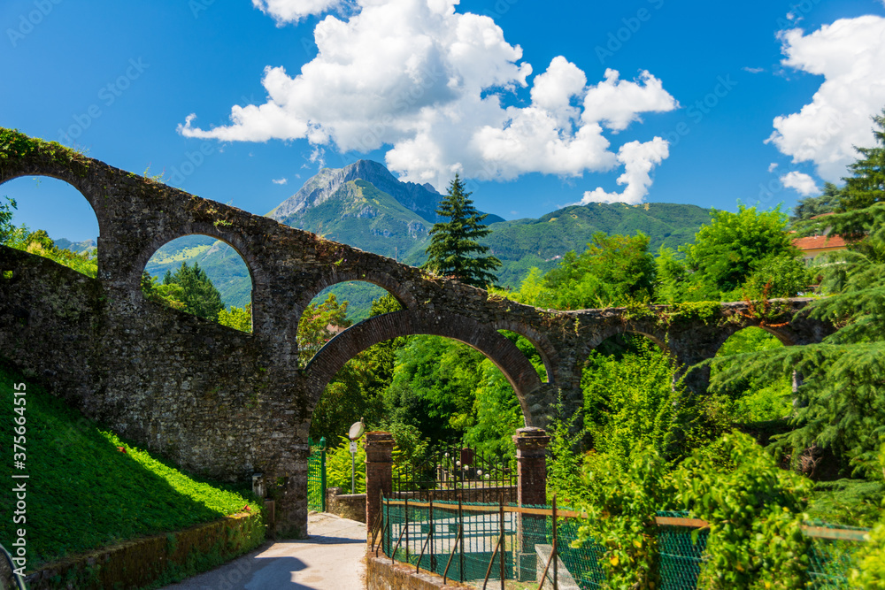 Ancient Aqueduct of Barga was built in the course of the 15th century. It's a stone construction that assured water to the fountains in the historical centre. Barga, Garfagnana - Tuscany,. Italy - obrazy, fototapety, plakaty 