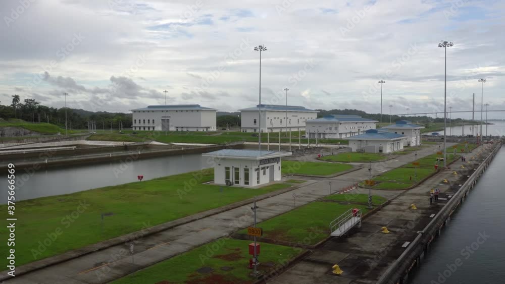 Panama Canal / Panama - November 2019: Wide shot of small buildings as the ship slowly moving through Agua Clara locks Panama Canal / Panama - November 2019: Wide shot of small buildings as the ship slowly moving through Agua Clara locks