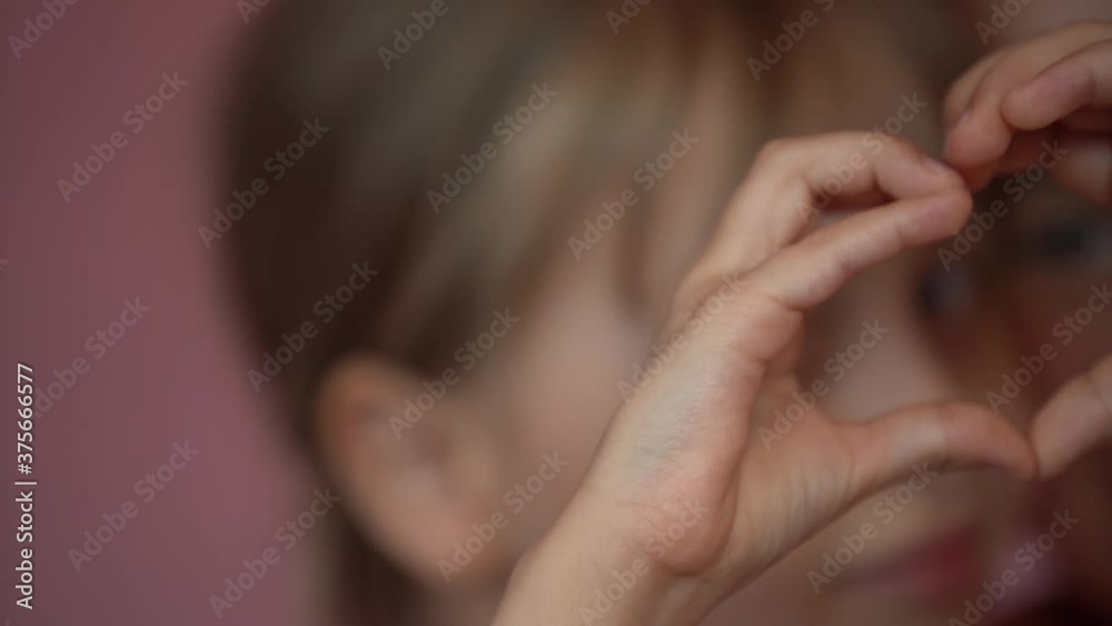 Video portrait of two happy little girls show heart gesture by two hands, looking at camera. Sweet caucasian little girls on a pink background Video portrait of two happy little girls show heart gesture by two hands, looking at camera. Sweet caucasian little girls on a pink background