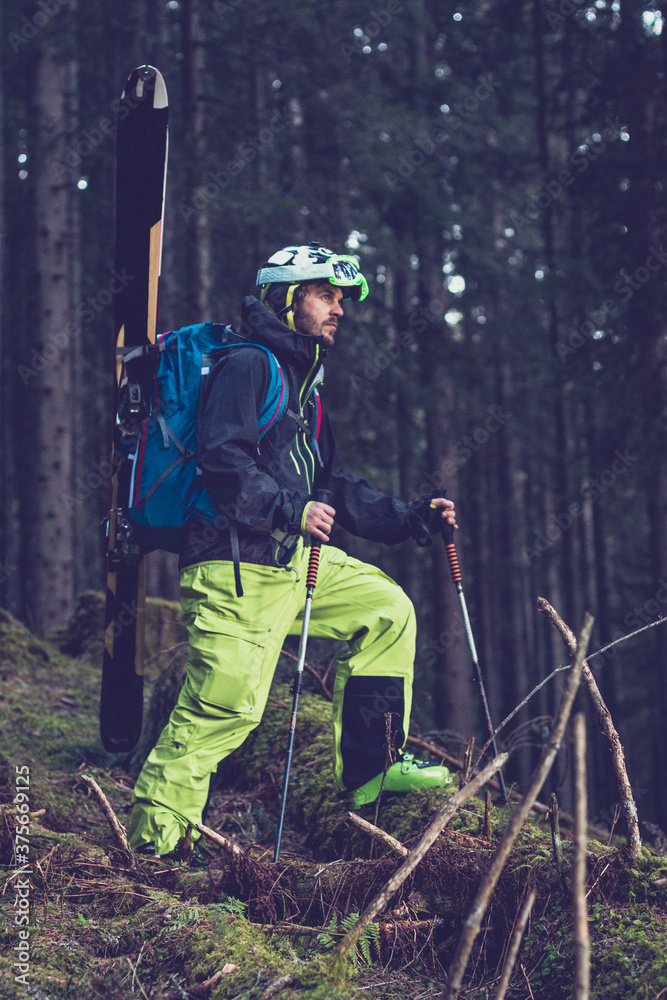 Freerider walking through the forest with his whole skiing equipment Freerider walking through the forest with his whole skiing equipment