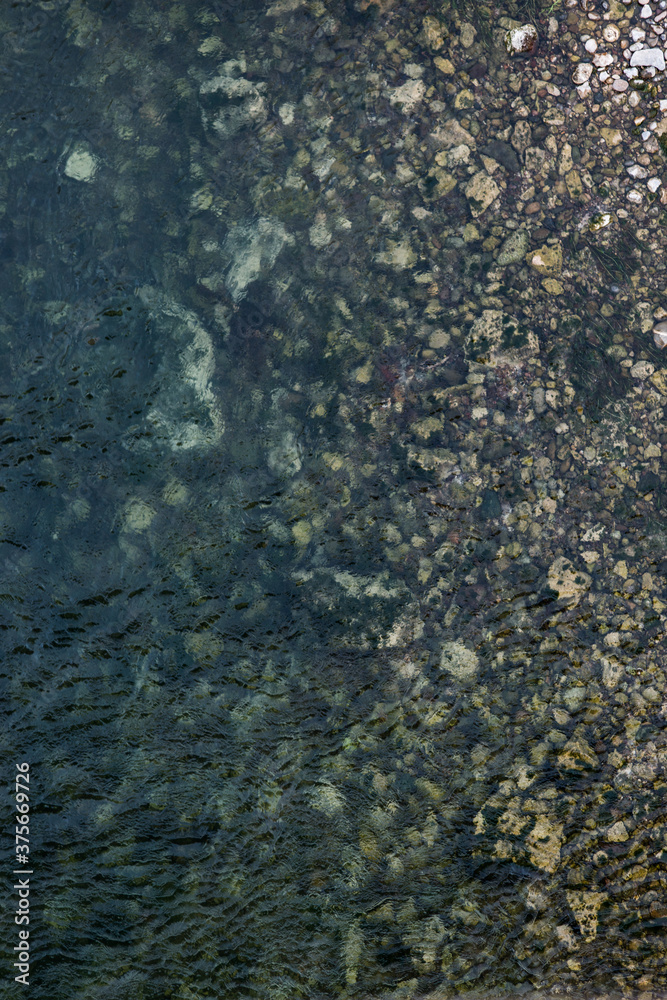 Aerial texture of one side of the river where it joins the shore formed of stones. Aerial texture of one side of the river where it joins the shore formed of stones.