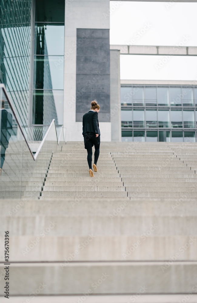 Businesswoman walking on the steps of a big company Businesswoman walking on the steps of a big company