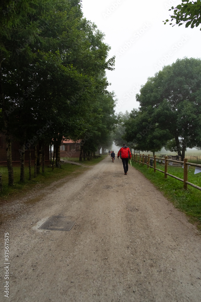 Personas andando por un camino de tierra en medio de niebla Personas andando por un camino de tierra en medio de niebla