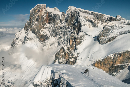 young man is skiing down a steep slope in old, nostalgic skiing equipment photo