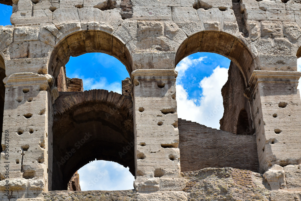 Windows of the Colosseum in Rome from which you can see the blue sky with scattered clouds