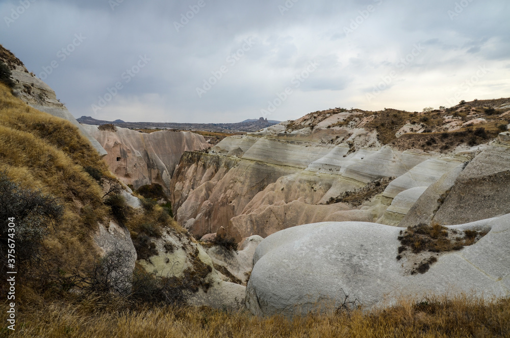 Naklejka premium Natural valley with volcanic tuff stone rocks in Goreme in Cappadocia, Central Anatolia region of Turkey. Popular tourist destination in Turkey for trekking.