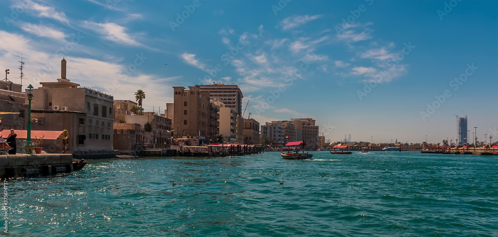 A view down the Dubai Creek towards an Abra taxis station in the UAE in springtime