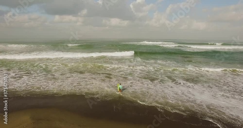 Aerial view of surfer onshore looking into distance, waiting, Canggu, Bali