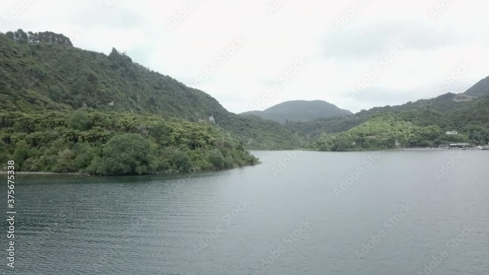 Aerial shot of green forested hills by shore at Tarawera, New Zealand Aerial shot of green forested hills by shore at Tarawera, New Zealand