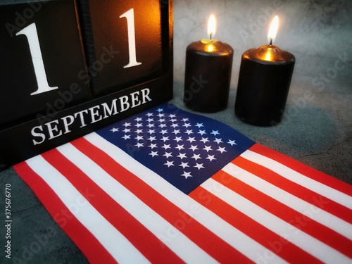 September 11th. Patriot Day and Memorial concept.
Two burning candles with United States of America flag on dark background. Copy space.  photo