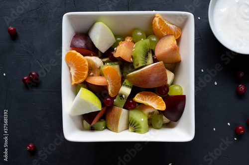 healthy salad from fresh fruit on a dark table
