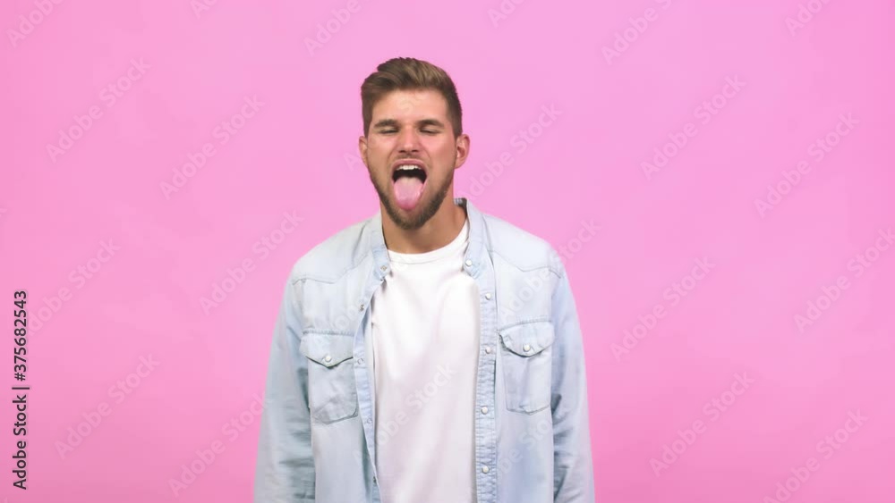 Young caucasian handsome man expression of confidence and emotion, fun and friendly, showing tongue as a sign of play or fun Young caucasian handsome man expression of confidence and emotion, fun and friendly, showing tongue as a sign of play or fun