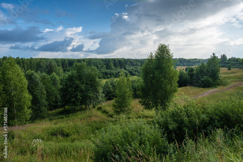 Landscape with forests and small meadows and a beautiful cloudy sky.