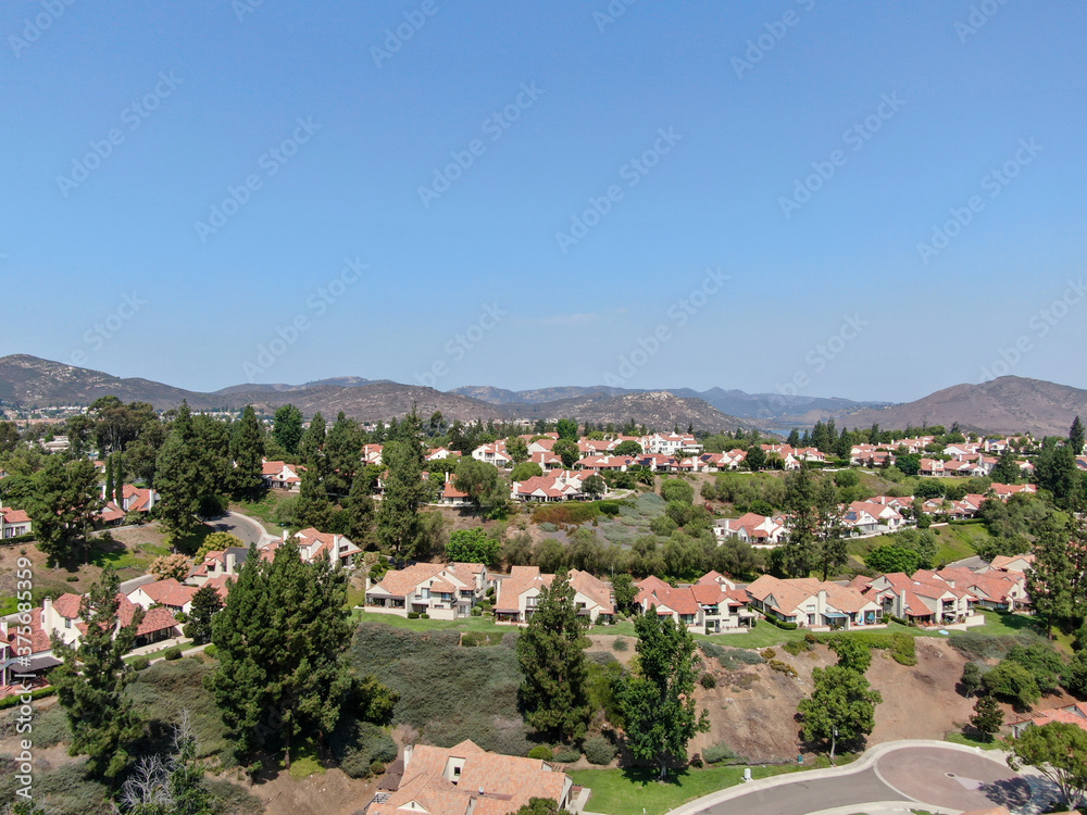 Aerial view of middle class neighborhood with residential house community and mountain on the background in San Diego, South California, USA.