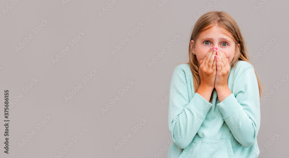 Young woman closing her mouth and wide open eye isolated on gray background Young woman closing her mouth and wide open eye isolated on gray background