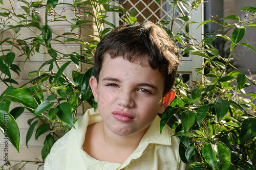 Bild auf Leinwand Close-up of a 7-year-old Brazilian child, finding it bad because it is in the middle of the foliage