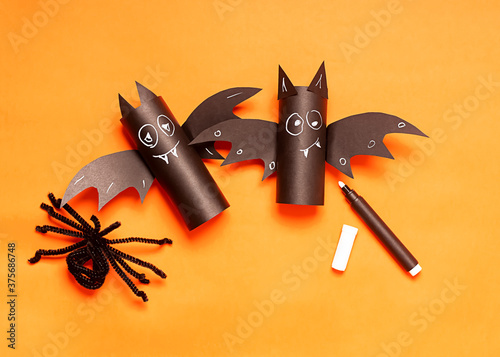 Halloween holiday concept. Two halloween toy bat, spider on the orange background. DIY For kids. Handcraft creative idea from toilet tube, recycle concept. Home decor project party.