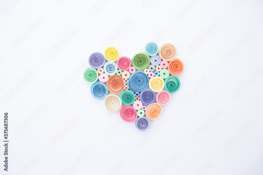 Heart from colored paper ribbons on a white background in the style of quilling. Heart from colored paper ribbons on a white background in the style of quilling.
