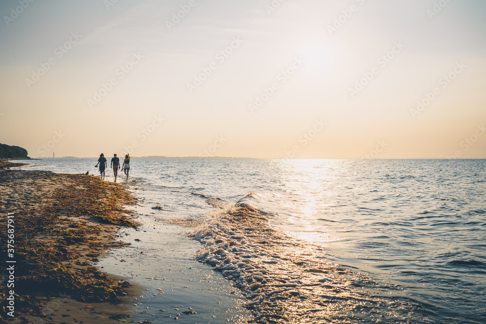 Menschen spazieren am Strand an der Ostsee