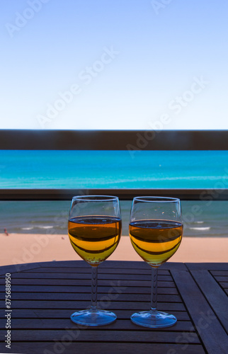 two glasses of cider on the table facing the sea